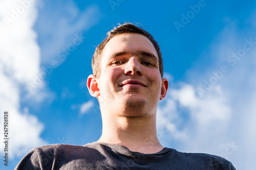 Gesicht eines lächelnden Jungen vor blauem Himmel