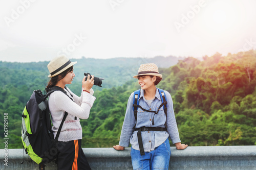 Two Asian tourists are taking pictures of the forest on the mountain. Travel in the holiday concept © lovelyday12