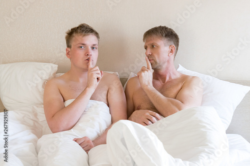 Handsome gay men couple on bed together. Love and relationships