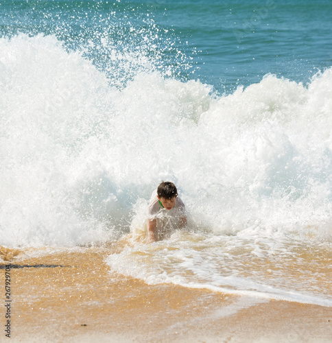 boy inside a wave on the beach