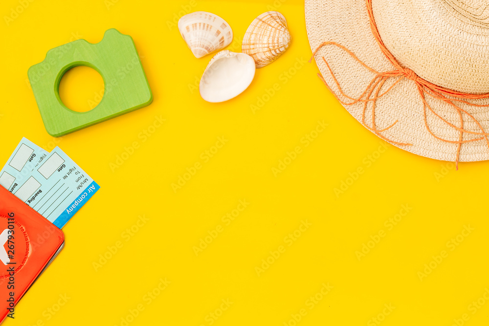 Funny vocation concept with camera, hat, passport and tickets on yellow background top view space for text Funny vocation concept with camera, hat, passport and tickets on yellow background top view space for text