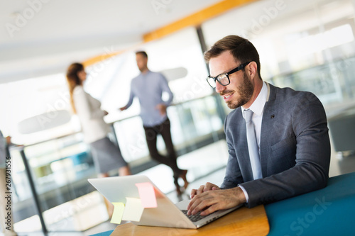 Handsome businessman working on laptop in office