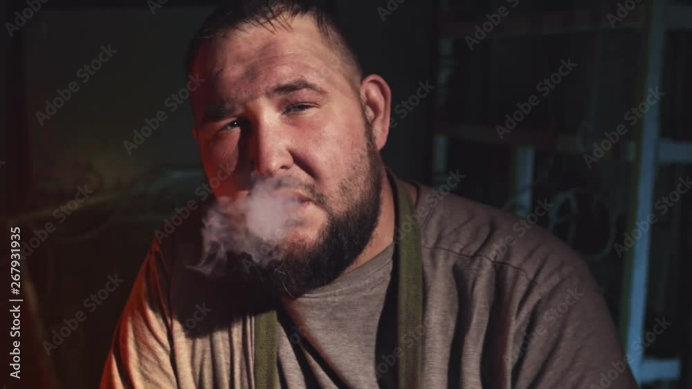 Russian blacksmith in his forge. Smoke break at a workplace Russian blacksmith in his forge. Smoke break at a workplace