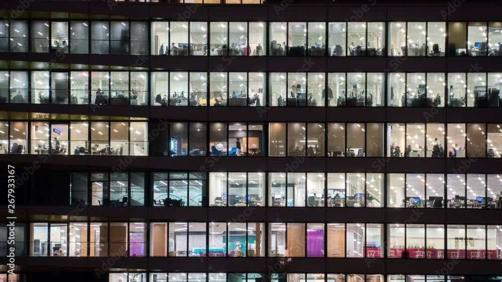 Timelapse at evening of a modern office building with glass windows
