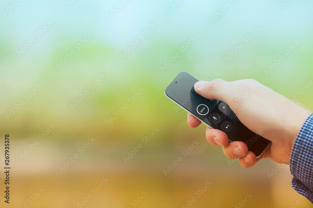 Hand holding remote control. Blured background. Remote control devices concept. Space for a text. Close up. Hand holding remote control. Blured background. Remote control devices concept. Space for a text. Close up.