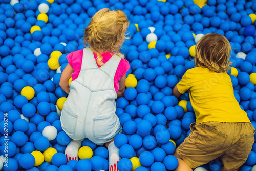 Children playing in ball pit. Colorful toys for kids. Kindergarten or preschool play room. Toddler kid at day care indoor playground. Balls pool for children. Birthday party for active preschooler photo