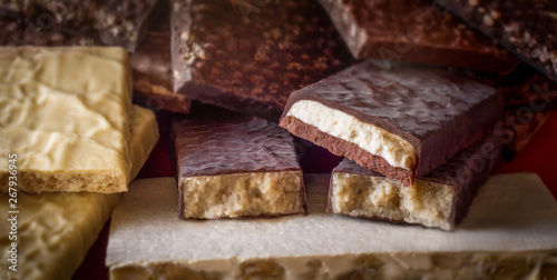 Turron. Festive sweets. Warm sunlight. Selective focus. Blurred background. Traditional Spanish Christmas candy. Torrone and nougat with nuts. Texture, layers.