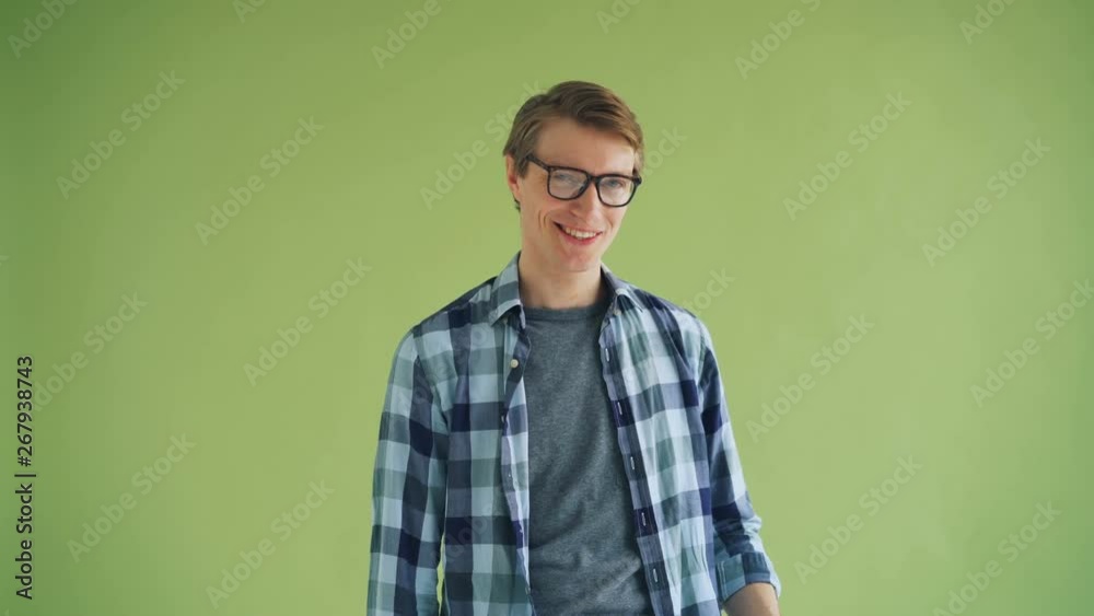 Portrait of attractive young man smiling sending air kiss and winking looking at camera on green background. Flirting, feelings and emotions, people concept. Portrait of attractive young man smiling sending air kiss and winking looking at camera on green background. Flirting, feelings and emotions, people concept.