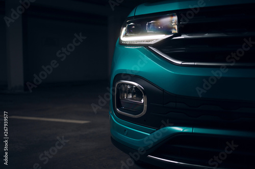 Modern crossover car front bumper with led headlight light. Fog light and headlight of SUV car at the dark