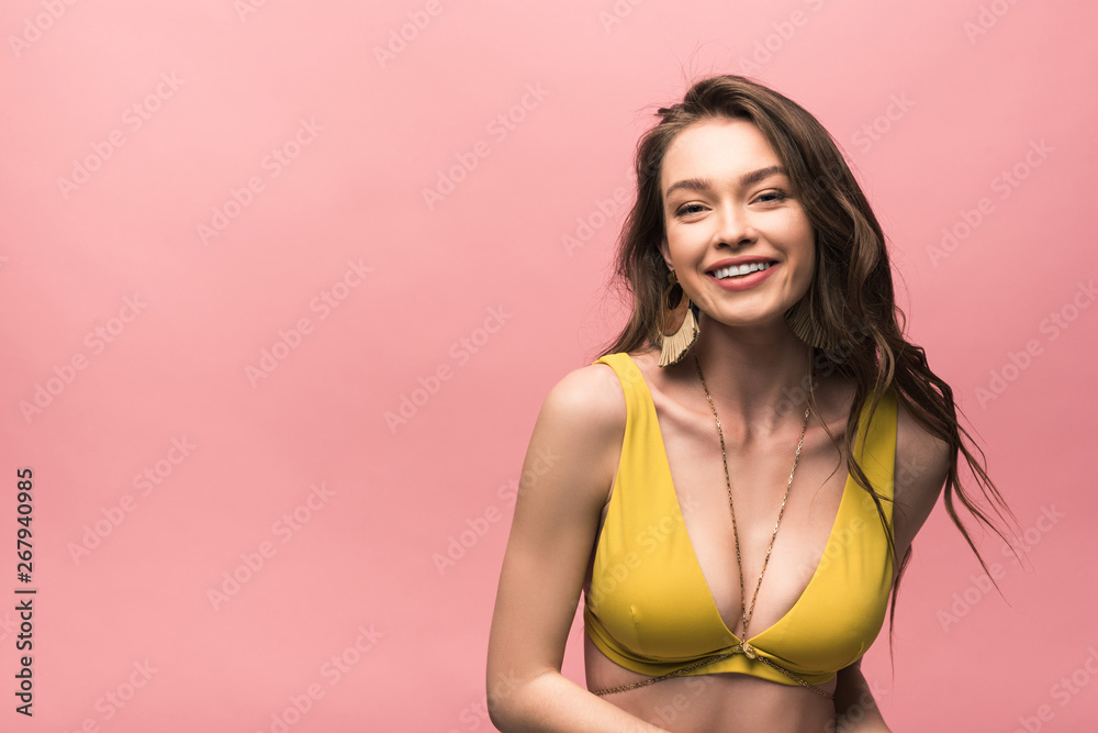 smiling young woman in yellow swimsuit isolated on pink - obrazy, fototapety, plakaty 