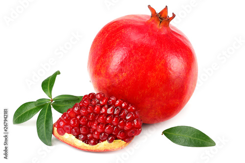 piece of pomegranate with seeds and green leaves isolated on a white background.