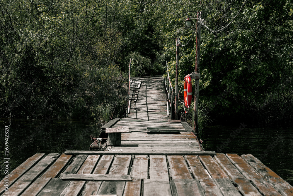 Fototapeta premium Wooden pier with a bright orange lifebuoy