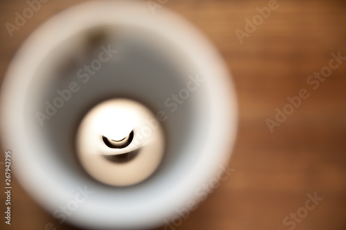 Reflection of lightbulb in a coffecup