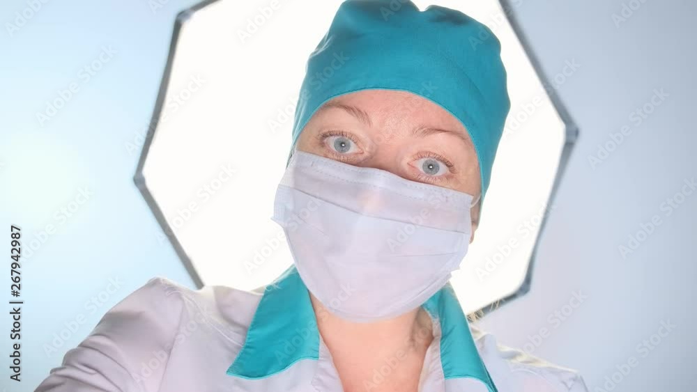 female surgeon treats a wound to a patient with a cotton swab in the operating room. female surgeon treats a wound to a patient with a cotton swab in the operating room.