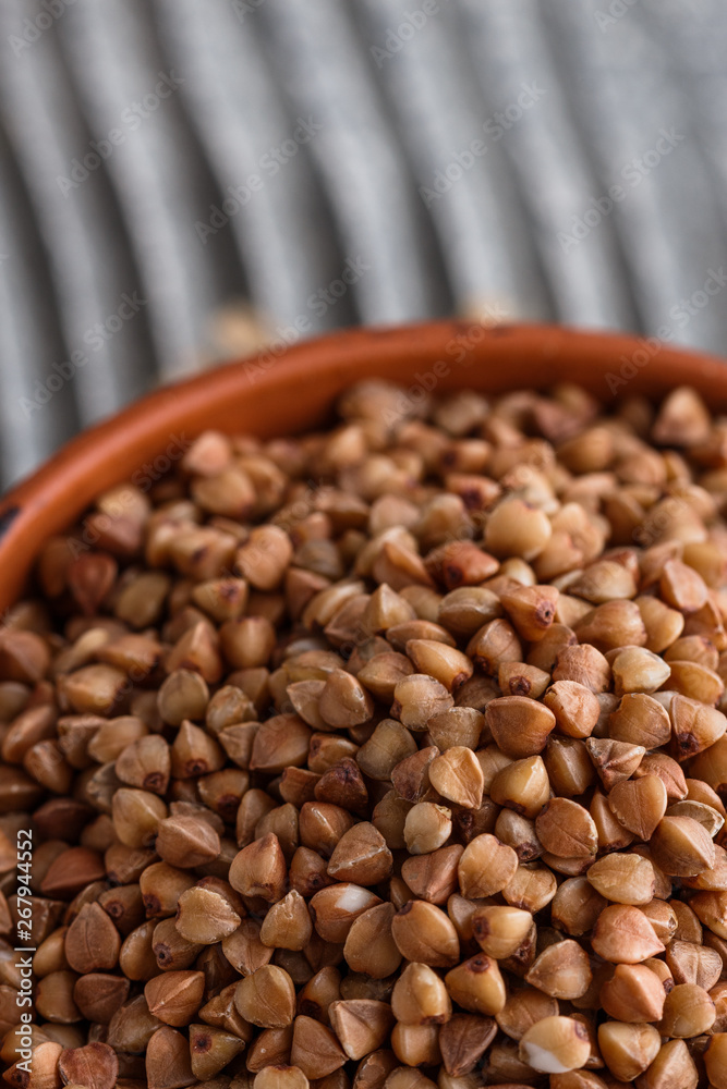 Fototapeta premium Grain buckwheat on a gray wooden background