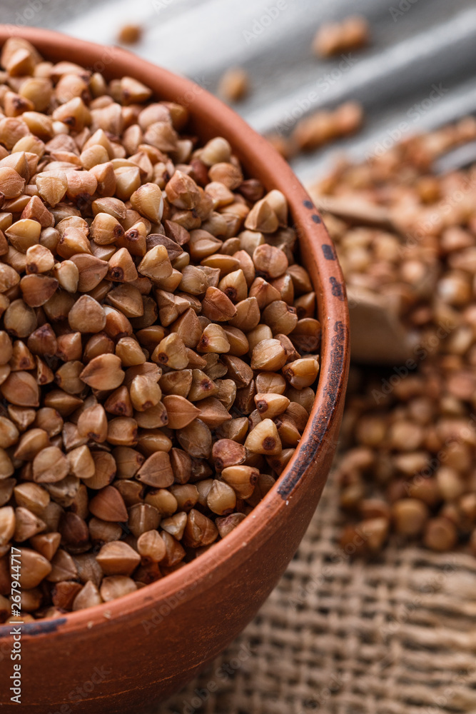 Fototapeta premium Grain buckwheat on a gray wooden background