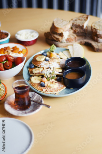 Delicious breakfast with pancakes and tea on a table