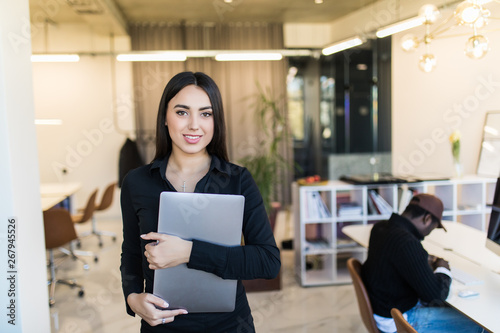 Portrait of smiling businesswoman with laptop in the office