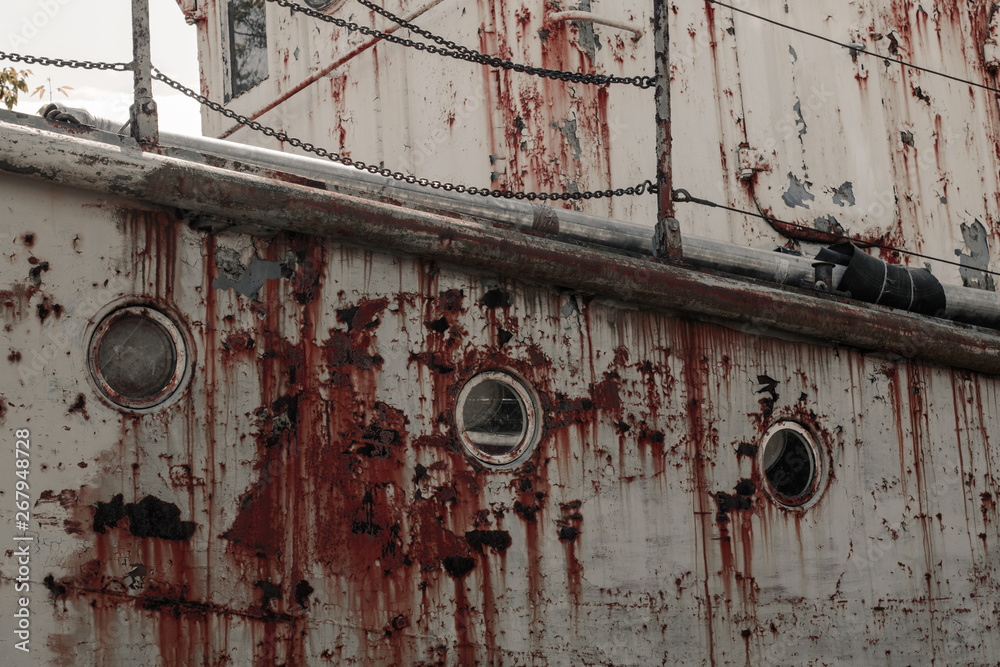 Board with portholes of an old rusty abandoned ship