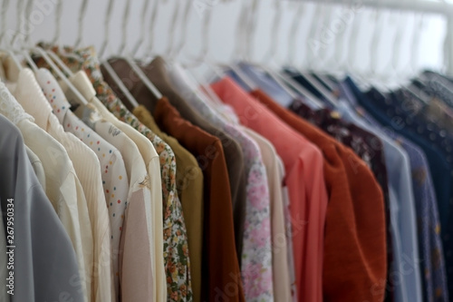 Colorful tops and blouses on a clothes rack. Quirky and whimsical wardrobe. Selective focus.