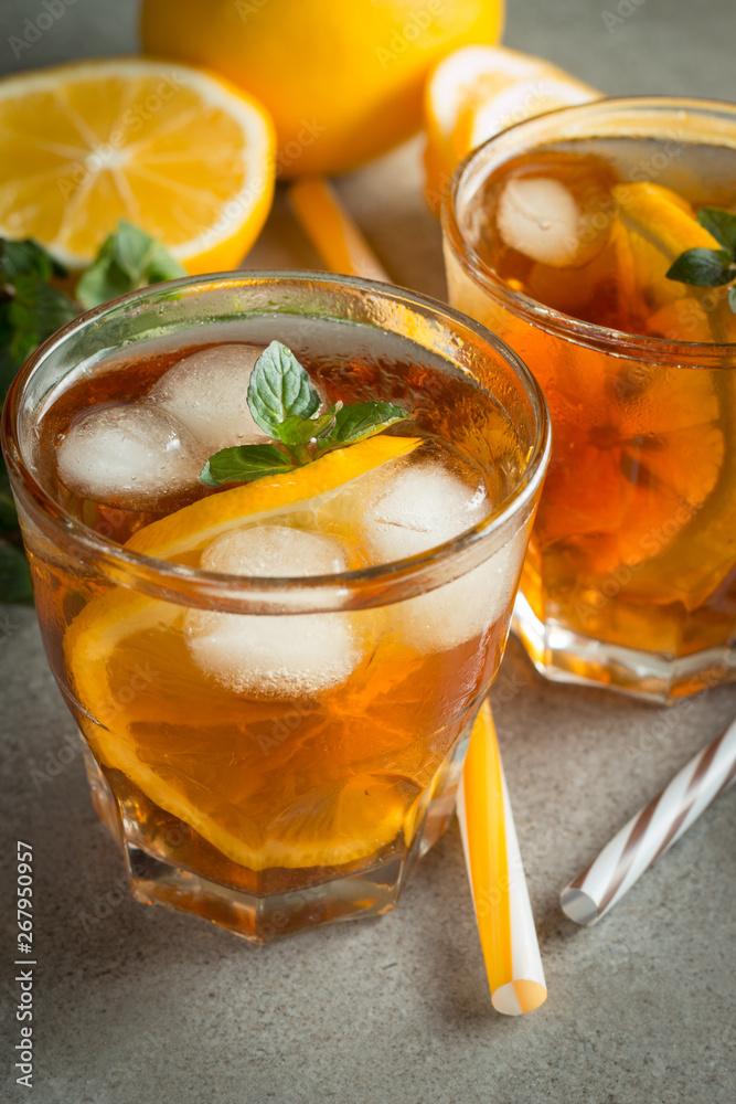 Glasses of cold ice tea with lemon, ice, mint on background. Homemade lemonade. Spring and summer drinks and beverages concept. Glasses of cold ice tea with lemon, ice, mint on background. Homemade lemonade. Spring and summer drinks and beverages concept.