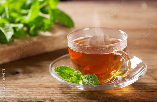 cup of tea with mint on wooden table