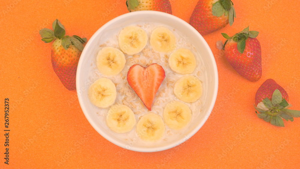 Ceramic bowl with oatmeal porridge with bananas and strawberry Ceramic bowl with oatmeal porridge with bananas and strawberry
