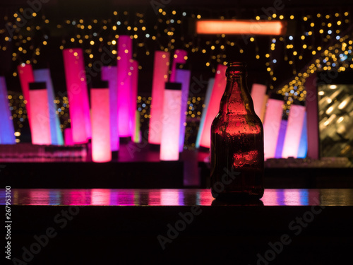 Dark glass beer bottle at the bar counter