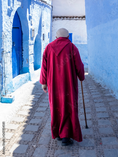 Anciano con  bastón paseando por las calle de Chauen, Marruecos photo