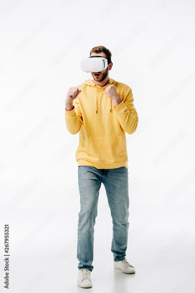 young man in blue jeans and yellow hoodie imitating boxing while using virtual reality headset on white background young man in blue jeans and yellow hoodie imitating boxing while using virtual reality headset on white background