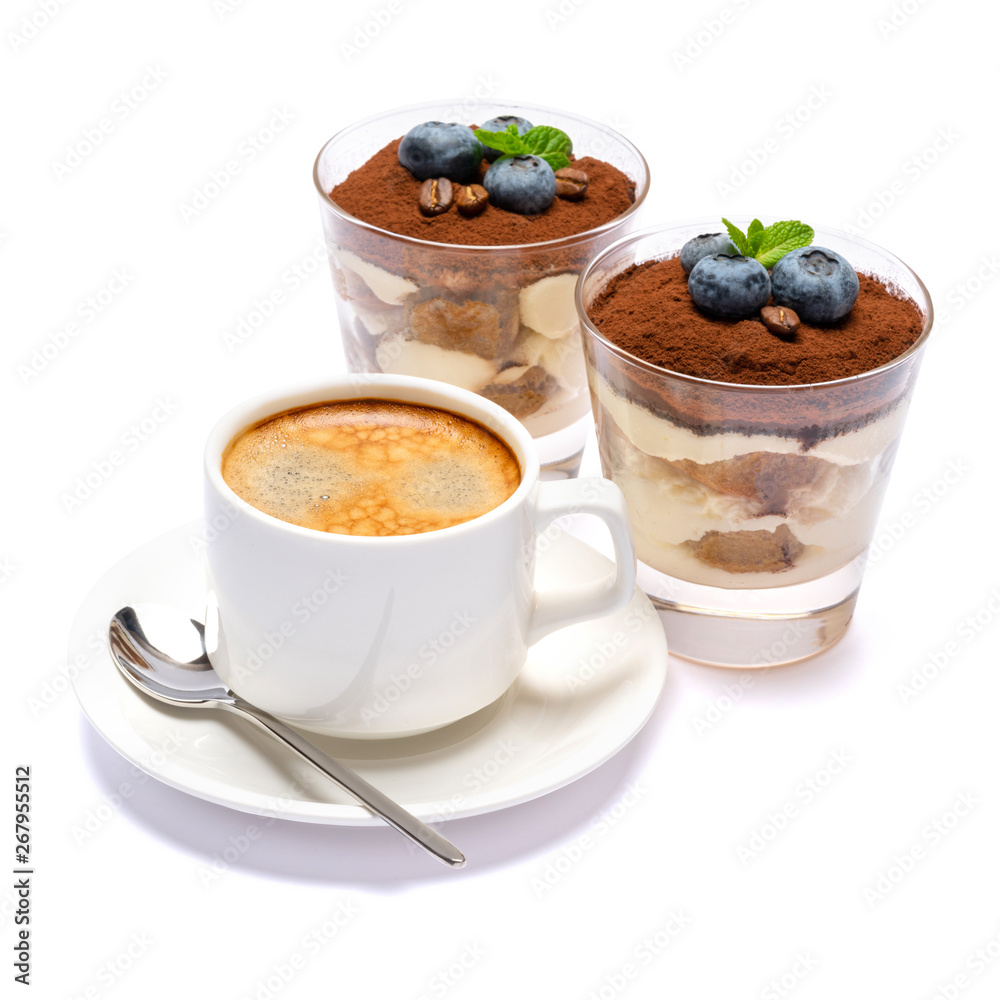 Classic tiramisu dessert with blueberries in a glass and cup of coffee isolated on a white background with clipping path Classic tiramisu dessert with blueberries in a glass and cup of coffee isolated on a white background with clipping path