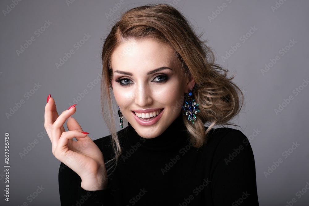 Obraz premium Beautiful woman with gentle smile on grey background.
