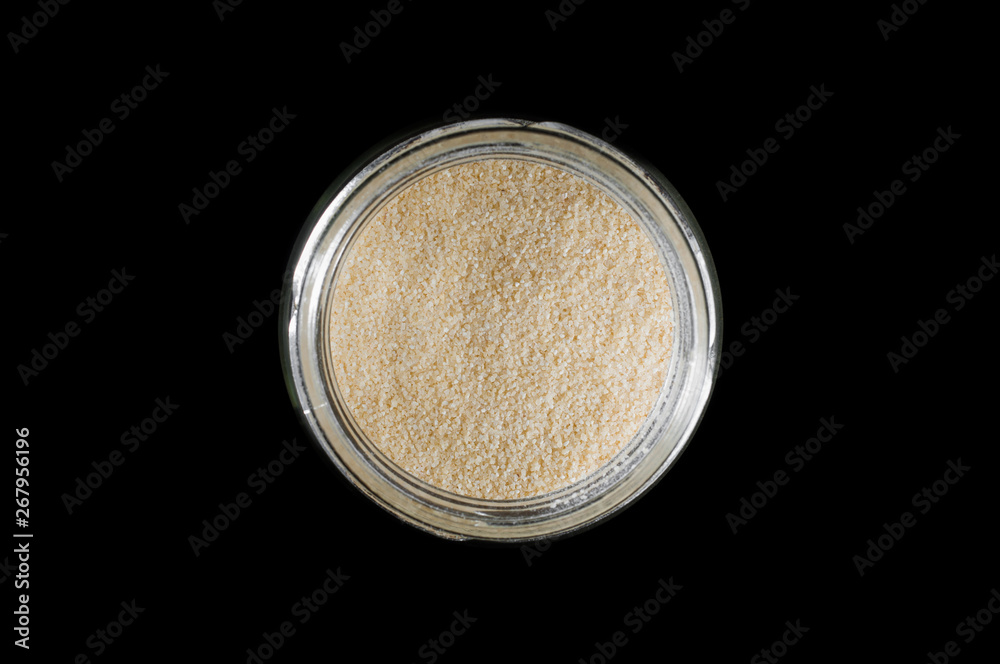 Couscous groats in a round glass jar on a black background, isolate. Couscous groats in a round glass jar on a black background, isolate.