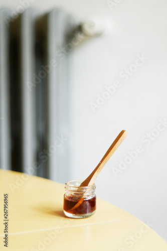 Jar of honey with wooden spoon on a table
