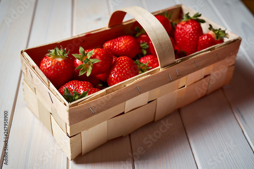 fresh juicy red strawberries in basket on white table