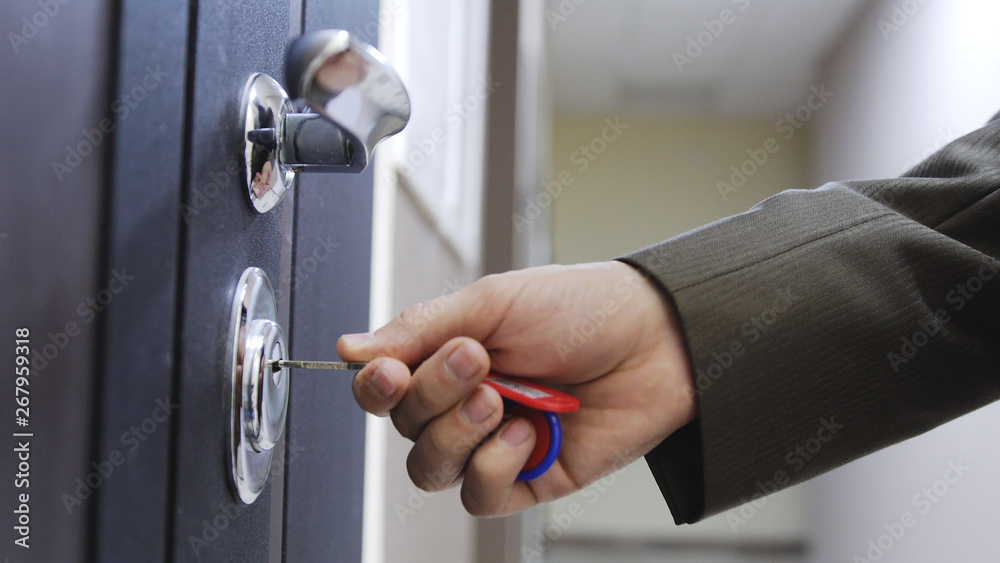 Obraz premium Close up of male hand unlocks a house's door with key