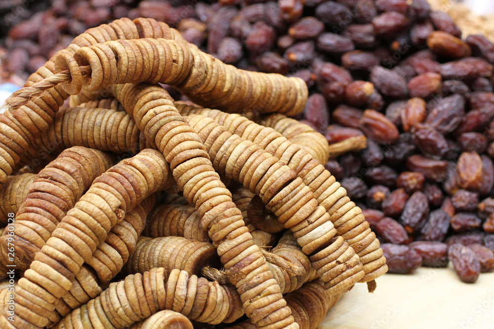 Big dried dates and dried figs strung on twine, lying on a large counter at the market in Deira, Dubai Big dried dates and dried figs strung on twine, lying on a large counter at the market in Deira, Dubai