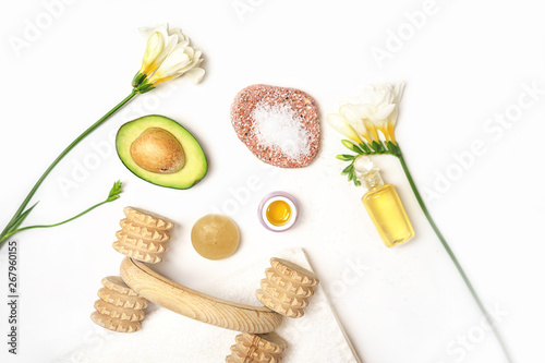 Beauty SPA sauna concept avocado, skin care facial essence oil, brush, flower and towel on white background. Natural cosmetics. Healthy skin, facial and body care. Flat lay. Selective focus.