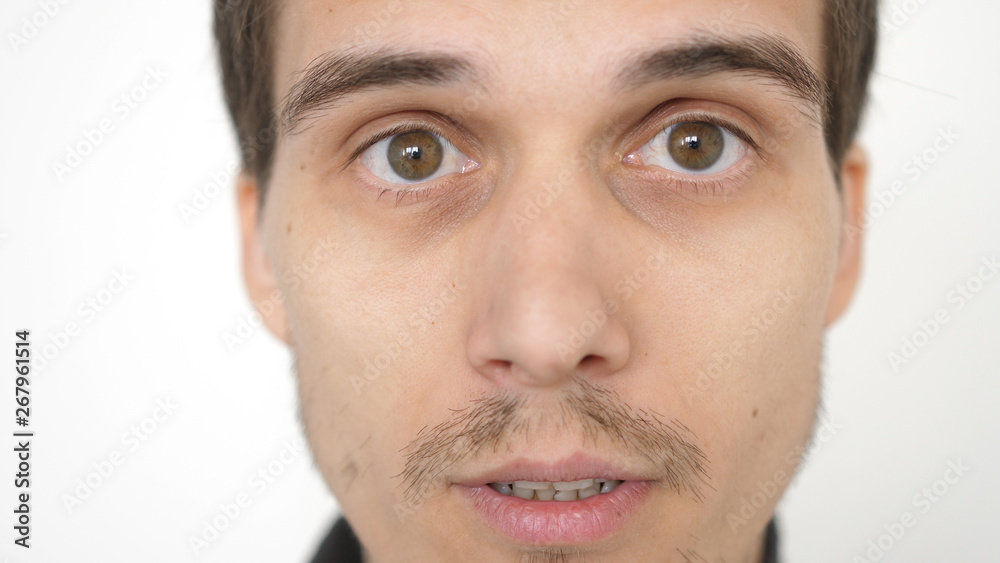 Close-up of a surprised emotional man with brown eyes looking into the camera. Close-up of a surprised emotional man with brown eyes looking into the camera.