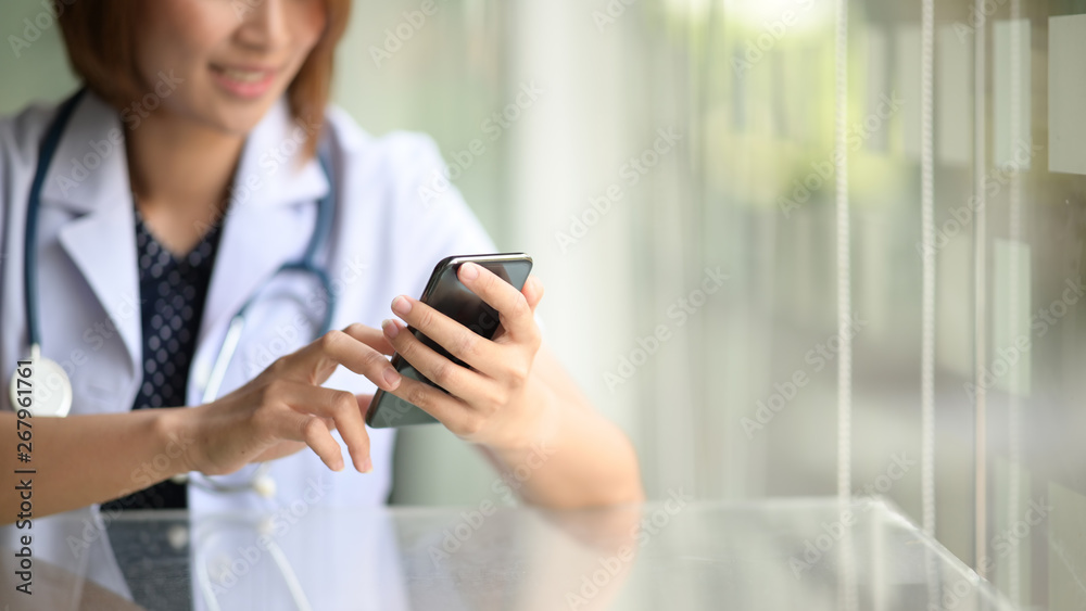 Female doctor hold mobile smartphone and point in touch screen Female doctor hold mobile smartphone and point in touch screen