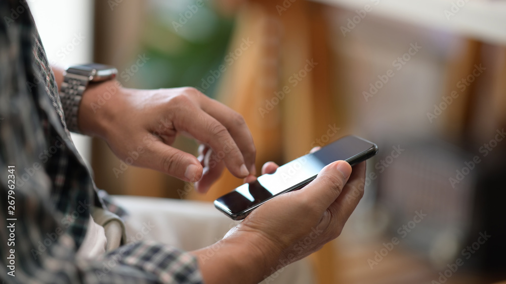 Male hands using mobile phone in workplace