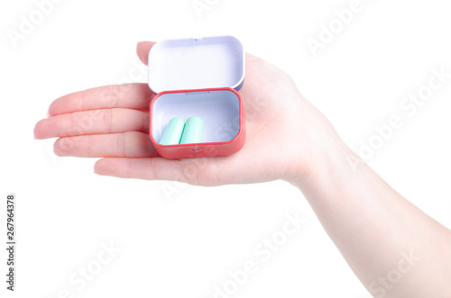 Hand holding green ear plugs in container on white background isolation