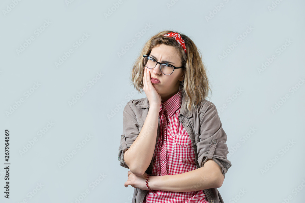 Fototapeta premium Emotional portrait of a fair-haired girl on a gray background, stormy emotions, business concept.