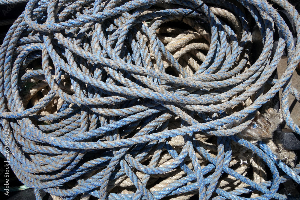 coils of used and grungy nylon blue lobster trap rope Horizontal
