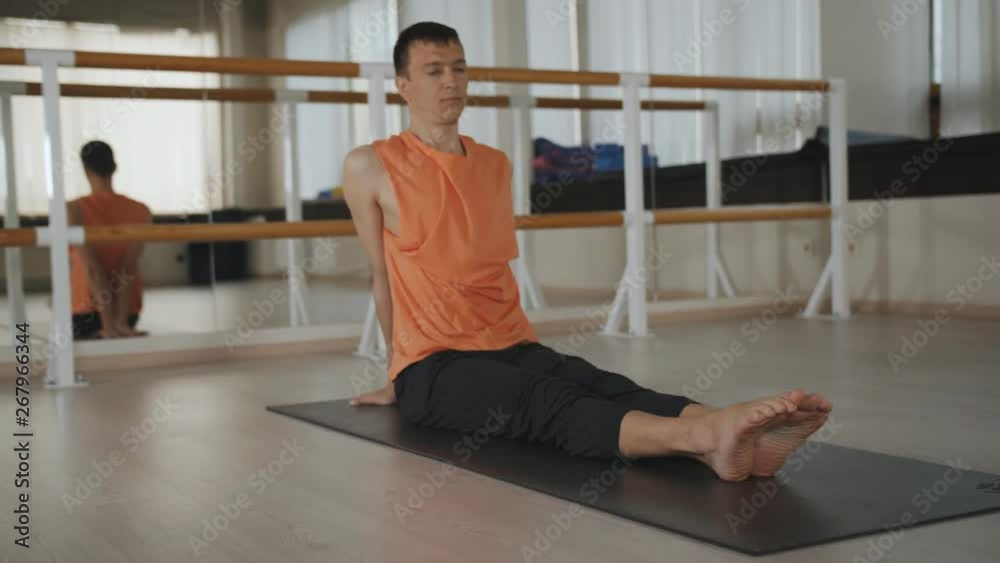 Man performs yoga exercises. Yoga in the sports centre. Very very male performs a complex of yoga exercises. Man performs yoga exercises. Yoga in the sports centre. Very very male performs a complex of yoga exercises.