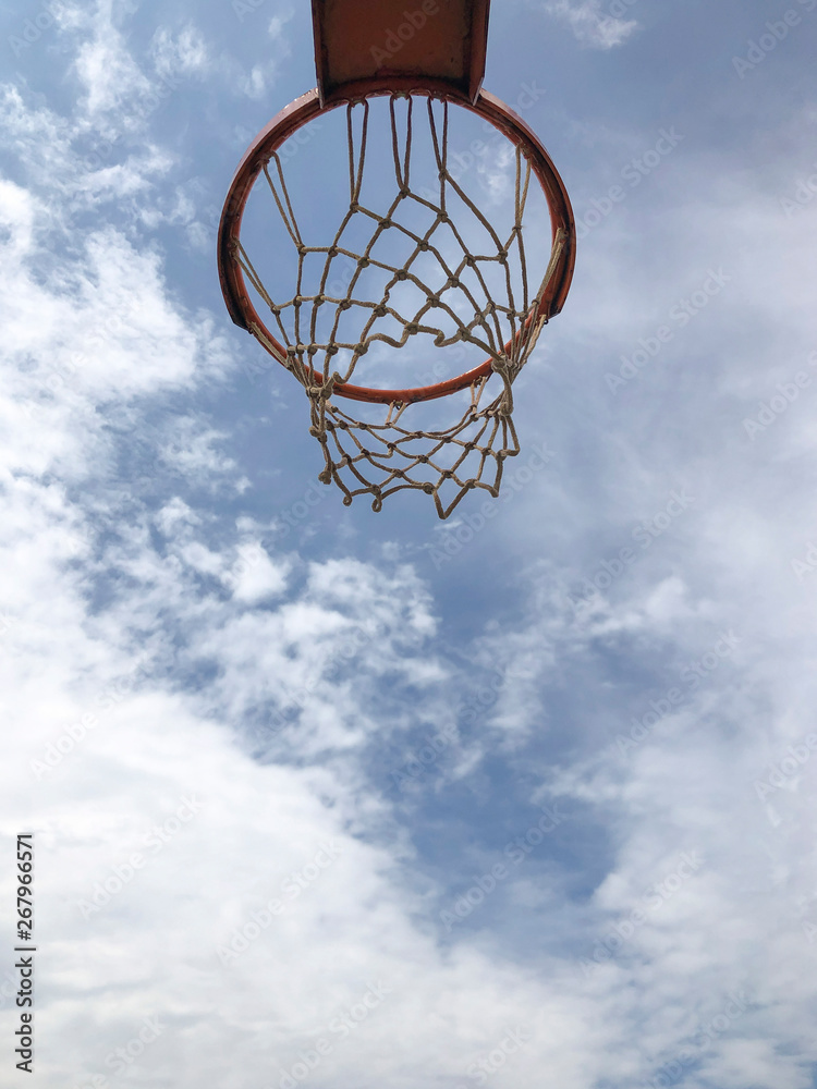 Basketball hoop against blue sky in a sunny day