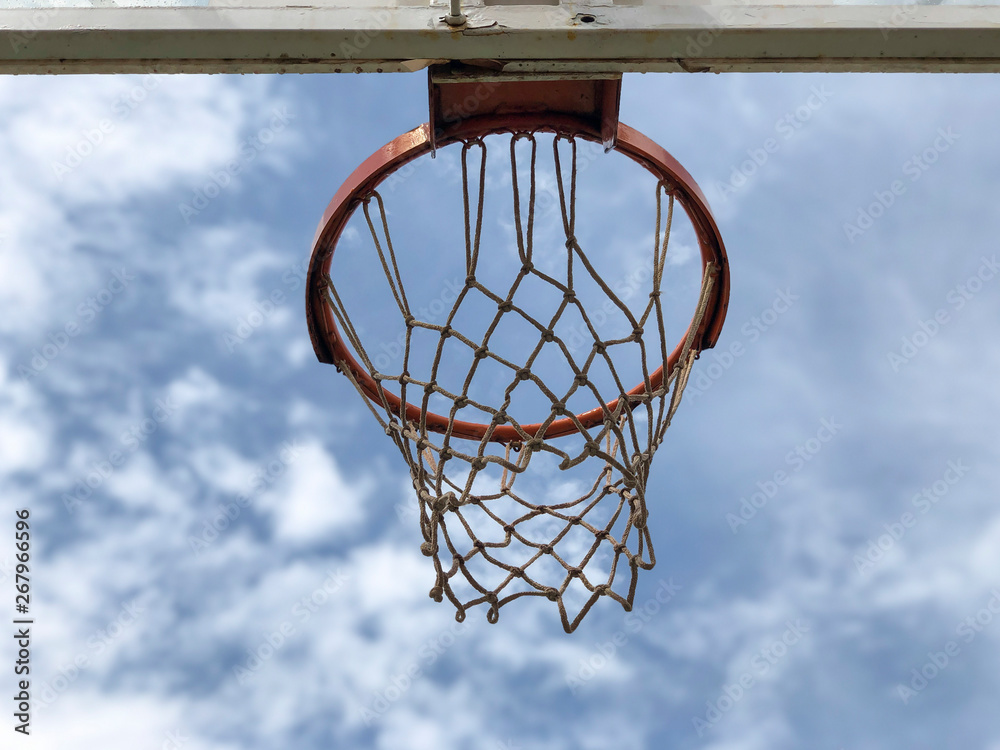 Basketball hoop against blue sky in a sunny day