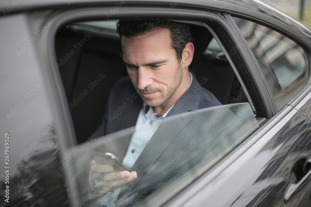 © merla - Handsome businessman sitting in a car