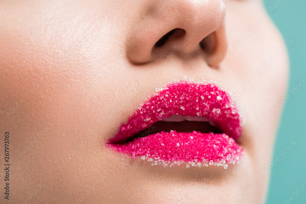 Fototapeta premium cropped view of woman with sugar on lips isolated on blue