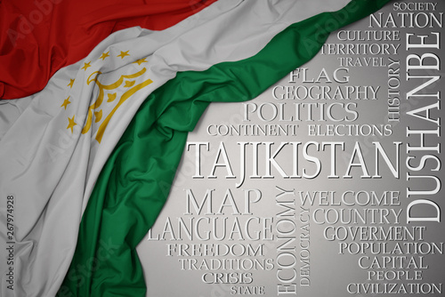 waving colorful national flag of tajikistan on a gray background with important words about country
